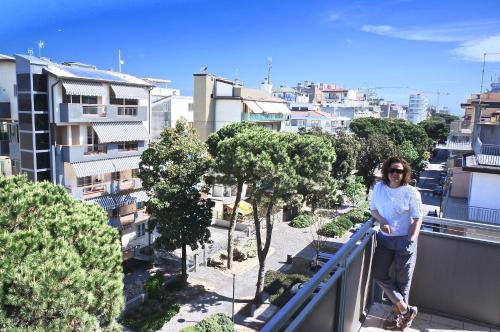 una donna sul balcone di un edificio di Hotel Belvedere a Sottomarina