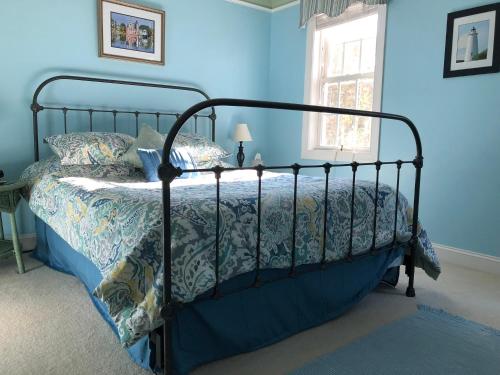 1 dormitorio con 1 cama con pared azul en The Inn on Bath Creek, en Bath