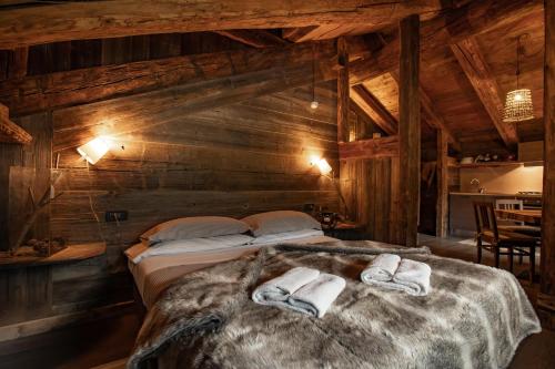 um quarto com 2 camas num chalé de madeira em Chalet Svizzero Apartments em Courmayeur