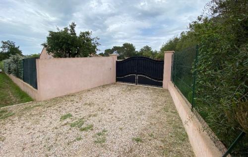 a fence with a black gate in a yard at maison jumelée in Le Cannet-des-Maures