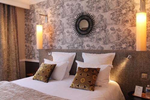 a bedroom with a bed with pillows and a mirror at Maison Lia in Châlons-en-Champagne
