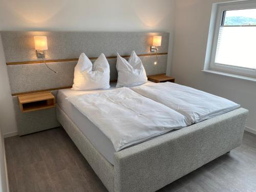 1 dormitorio con 1 cama con sábanas y almohadas blancas en Ferienhaus Koch, en Bad Staffelstein