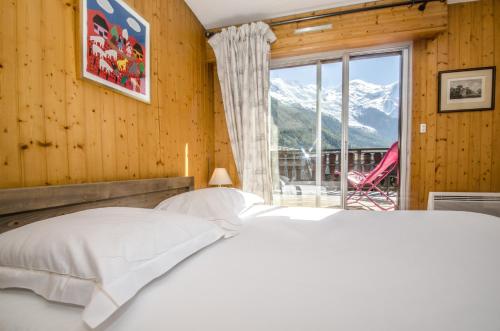 um quarto com uma cama e uma grande janela em Résidence Clos Du Savoy em Chamonix-Mont-Blanc