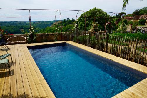 a small swimming pool on a deck with a fence at 1 logis à Domme - Piscine & SPA in Domme