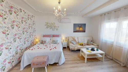 1 dormitorio con 1 cama con papel pintado de flores en Apartamentos Oncemolinos con desayuno en Consuegra