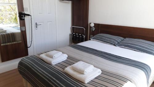 a bed with two pillows and a towel on top of it at Blossom Guest House in Edinburgh