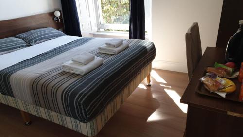 a bed in a room with a wooden floor at Blossom Guest House in Edinburgh