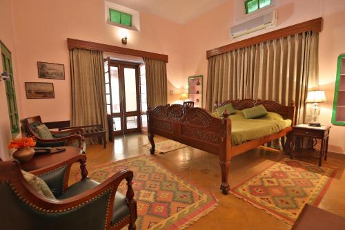 a bedroom with a bed and chairs in a room at Roop Niwas Kothi, Near Mandawa in Nawalgarh