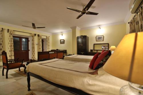 a large bedroom with two beds and a lamp at Roop Niwas Kothi, Near Mandawa in Nawalgarh