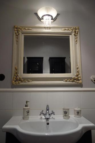 ヴロツワフにあるPrzyjazny Apartamentのバスルーム(鏡付き洗面台、上部の照明付)