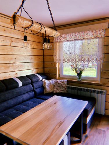 a living room with a couch and a wooden table at Domki u Danki in Brenna