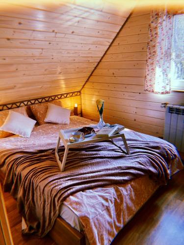 a bedroom with a bed with a table on it at Domki u Danki in Brenna