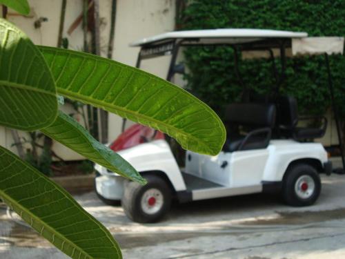 a small white golf cart parked next to a building at Floral Shire Suvarnabhumi Airport in Lat Krabang