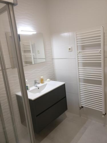 a white bathroom with a sink and a shower at Casa das Olmedas in Vimioso