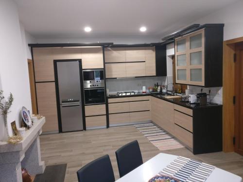 a kitchen with stainless steel appliances and a table and chairs at Casa das Olmedas in Vimioso