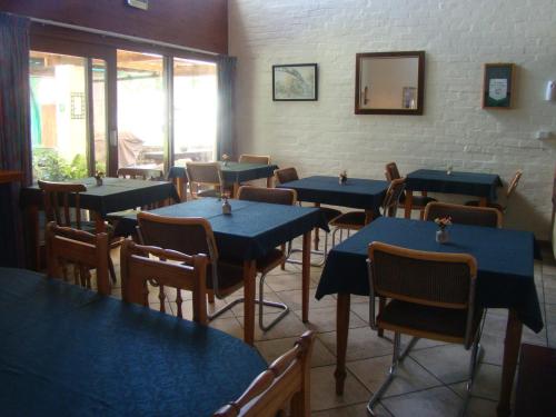 a dining room with blue tables and chairs at Aqua Marine Guest House in Port Elizabeth