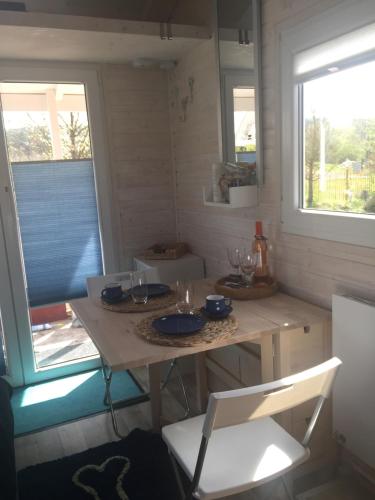 a table in a small room with two windows at Tinyhouse Bamberg in Pettstadt