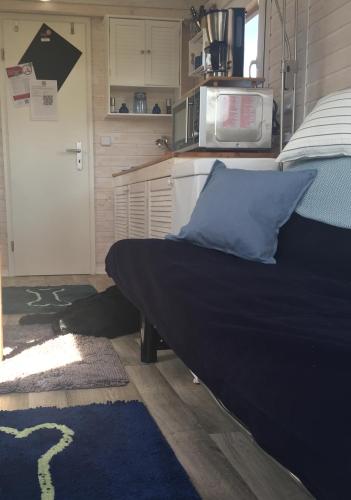 a bedroom with a bed with a microwave and a door at Tinyhouse Bamberg in Pettstadt