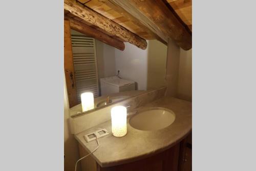 La salle de bains est pourvue d'un lavabo et de 2 bougies. dans l'établissement Chalet à la montagne 10 places 4 chambres, à Bonneval-sur-Arc