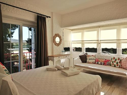 Le Vent Alaçatı Otel في إزمير: غرفة نوم بيضاء بها سرير ونافذة