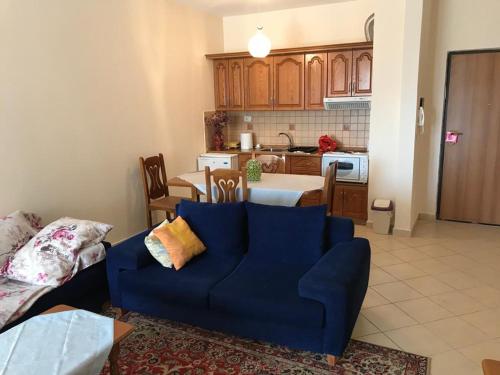 uma sala de estar com um sofá azul e uma cozinha em Seaside Apartment Durres em Durrës