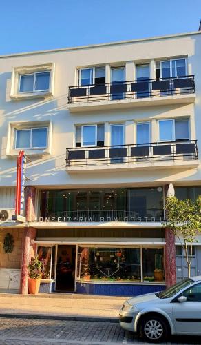 a building with a car parked in front of it at Fascinante Orbita Apartments in Vila Nova de Famalicão