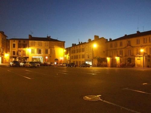 an empty city street at night with buildings and cars at Maison du Magnolia in Confolens