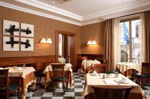 um restaurante com mesas e cadeiras num quarto em Hotel Mascagni em Roma