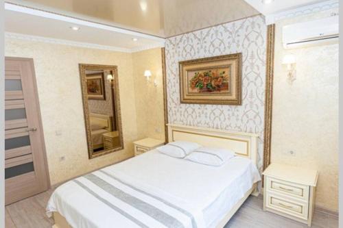 - une chambre avec un lit blanc et un miroir dans l'établissement Тараскова 16, Люкс, ЮЗР, à Tcherkassy