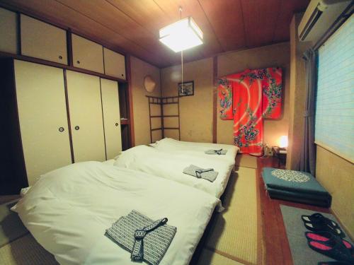 mały pokój z 2 łóżkami i lampką w obiekcie Uno Port Inn w mieście Tamano
