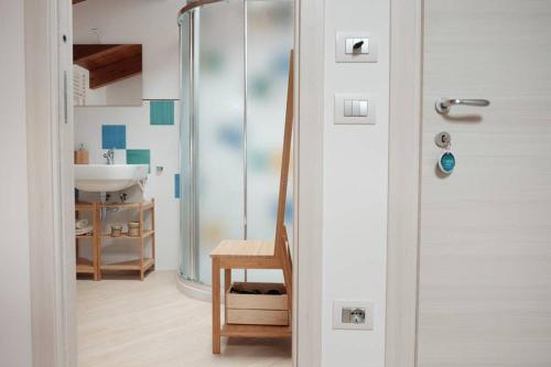 a bathroom with a shower and a wooden chair at APPARTAMENT '' IL GIARDINO '' in Santa Maria La Carità