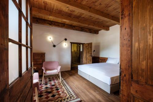 a bedroom with a bed and a chair at Almalomb Apartman in Hosszúhétény