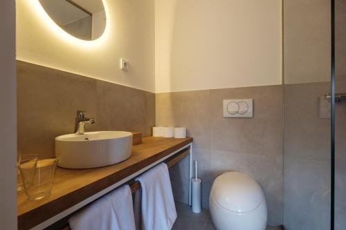 a bathroom with a sink and a toilet at Almalomb Apartman in Hosszúhétény