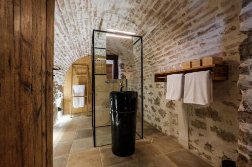 a bathroom with a glass shower in a brick wall at Almalomb Apartman in Hosszúhétény