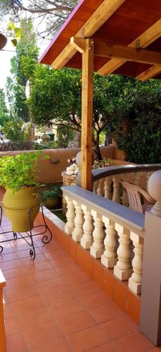 a porch with a white railing and a wooden roof at Castella Beach in Alissos