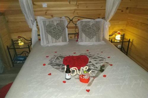 a bed with a heart with the word love on it at Charme Z'Aisne in Louâtre