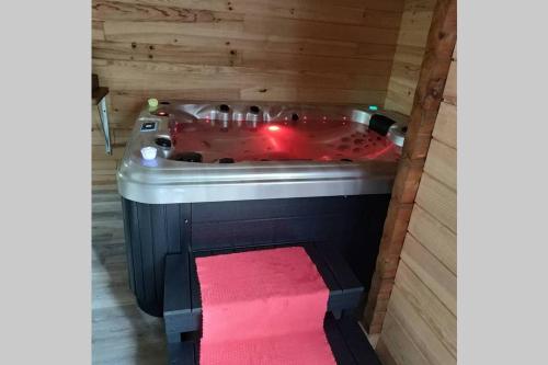 a hot tub in a wooden room with a pink towel at Charme Z'Aisne in Louâtre
