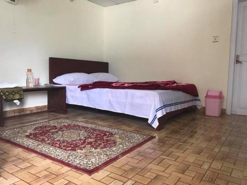 a bedroom with a bed and a rug on the floor at Pine Park Lodges in Shāhkot