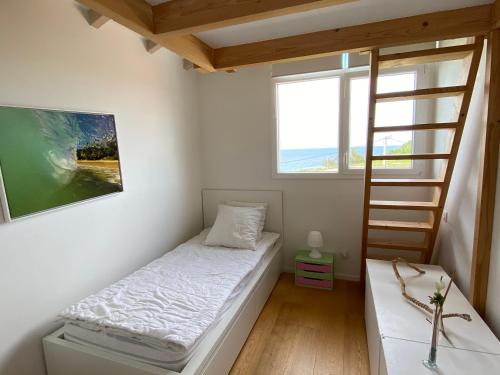 um pequeno quarto com uma cama e uma escada em Bel appartement vue mer - 1er rang front de mer em Saint-Jean-de-Luz