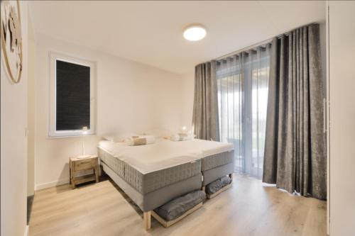a bedroom with a bed and a large window at Casa Bos Schotsman Wellness - Jacuzzi - Rental eBikes - The Kamado BBQ in Kamperland