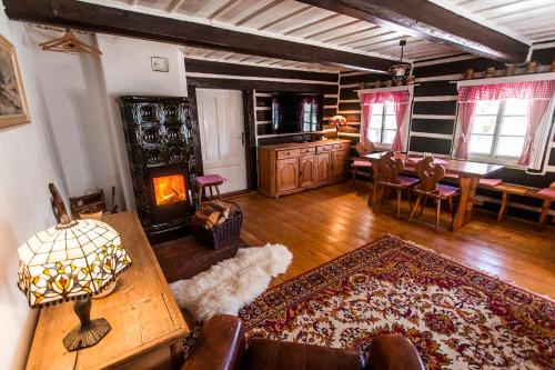 a living room with a fireplace and a dining room at Chalupa Šárka in Dolni Dvur
