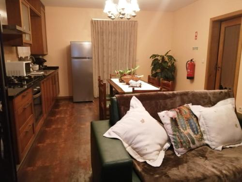 a living room with a couch and a kitchen at Casa Cima de Vila in Vieira do Minho