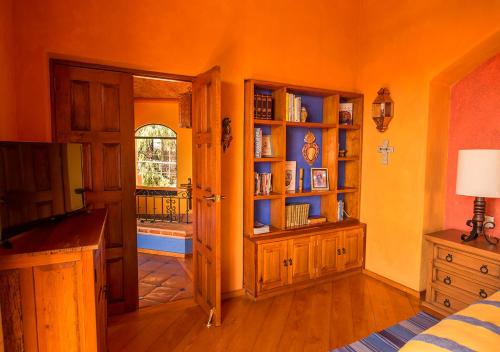 an orange room with a bedroom with a door and a window at Casa Estrella de la Valenciana Hotel Boutique in Guanajuato