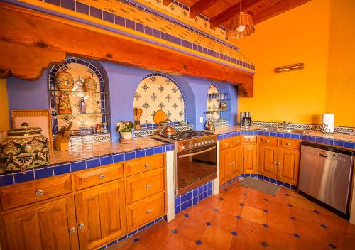 a kitchen with wooden cabinets and blue and yellow walls at Casa Estrella de la Valenciana Hotel Boutique in Guanajuato