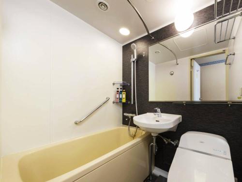 a bathroom with a sink and a tub and a toilet at Hotel Sapporo Garden Palace in Sapporo