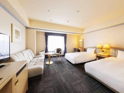 ein Hotelzimmer mit 2 Betten und einem TV in der Unterkunft Hotel Sapporo Garden Palace in Sapporo