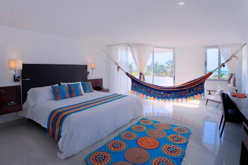 a bedroom with a bed and a hammock in it at Hotel Taroa in Ríohacha