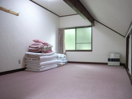 une chambre avec une pile de serviettes dans une chambre avec une fenêtre dans l'établissement Cottage All Resort Service / Vacation STAY 8399, à Inawashiro