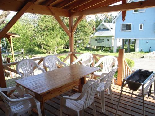 a wooden table and white chairs on a deck at Cottage All Resort Service / Vacation STAY 8399 in Inawashiro