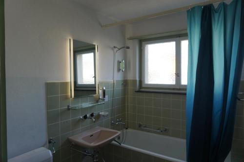 uma casa de banho com um lavatório, uma banheira e um espelho. em good bed wynau em Wynau